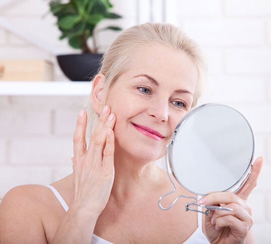 Woman in the mirror at skin tightening results from Beauty & Health by Liz