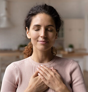 Woman holding her hands on her chest after BOTOX at Beauty & Health by Liz